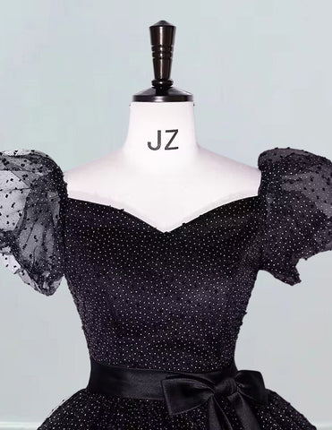a mannequin wearing a black dress with polka dots