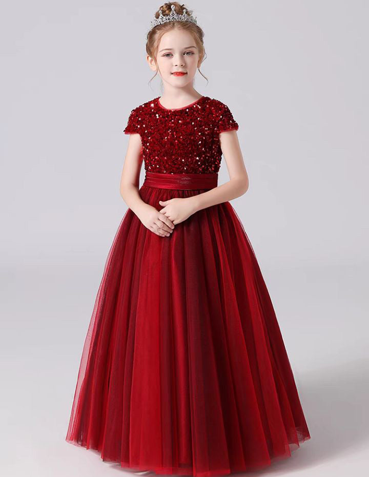 a little girl wearing a red dress and a tiara