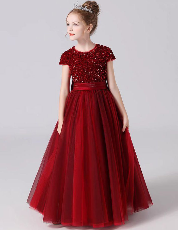 a little girl wearing a red dress with sequins