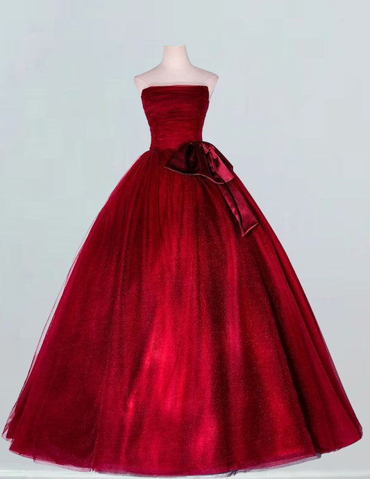 a red ball gown with a bow on the waist
