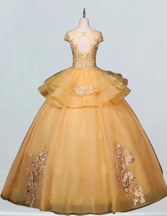 a yellow dress with gold appliques on it